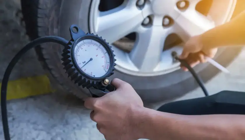 Contrôle de la pression pneu autoroute avec un manomètre. Assurer la sécurité avant le départ.
