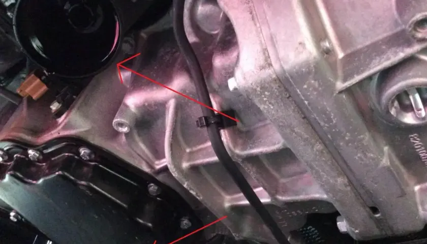 Vue détaillée du moteur d'une Scenic 3, montrant le carter d'huile et le filtre, lors d'une vidange.