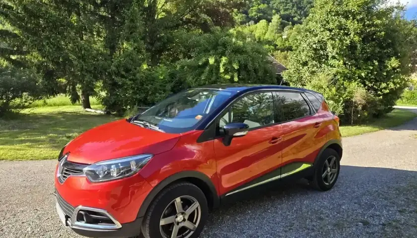 Renault Captur rouge garé dans un paysage verdoyant. Idéal pour connaître le prix révision Renault Captur 60000 km.