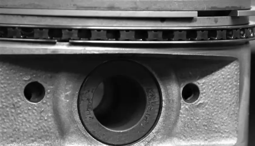 Gros plan sur un piston de moteur, montrant les segments et le logement de l'axe. La segmentation moteur est essentielle pour l'étanchéité.