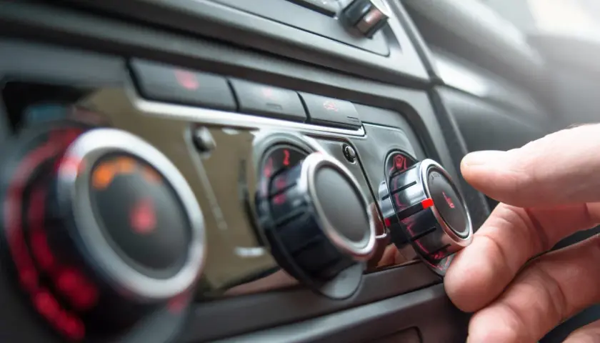 Main gauche sur le bouton de température, le chauffage de la voiture est réglé au maximum. Le liquide de refroidissement est peut-être bas.