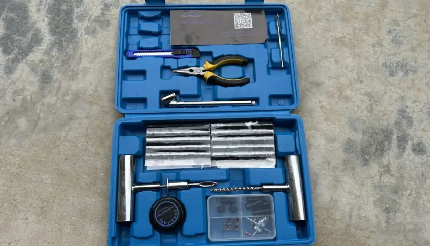 Kit de réparation pour pneu de voiture : mèches, pince, cutter, et outils pour une intervention rapide.
