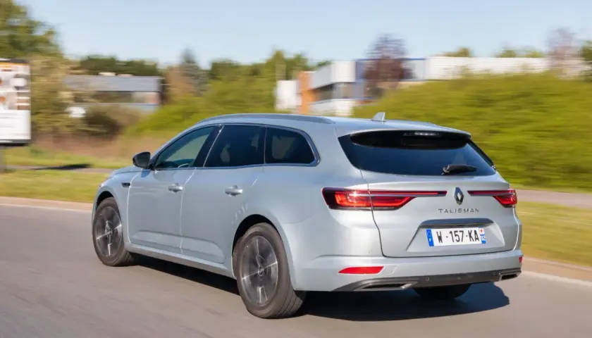 Vue arrière d'une Renault Talisman break argentée en mouvement. L'entretien de ce véhicule est essentiel pour sa longévité.