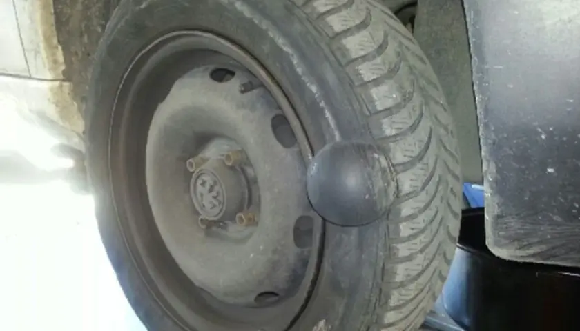 Gros plan sur une roue de voiture avec une hernie sur le pneu, signe d'un problème de sécurité.