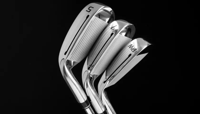 Trois fers de golf brillants, numérotés 5, 7 et PW, prêts pour une révision de golf 7.