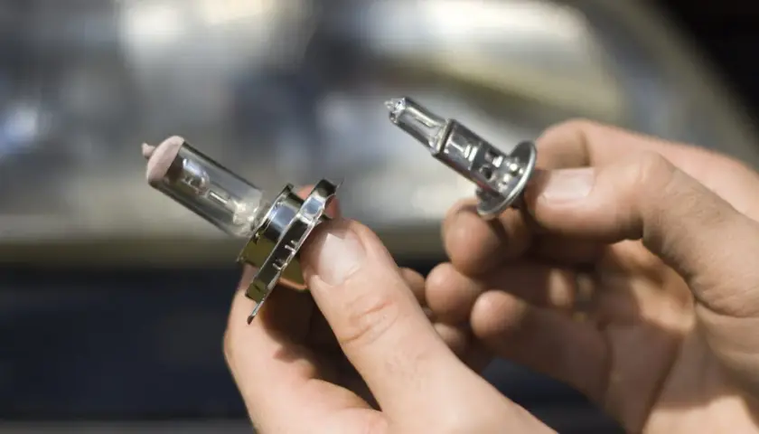 Deux ampoules H7 sont tenues dans des mains. Quelle voiture utilise ce type d'ampoule ?