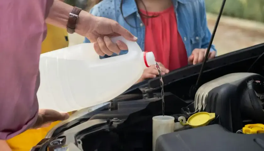 Main d'homme versant du liquide dans le réservoir, vérifiant le niveau liquide de frein.
