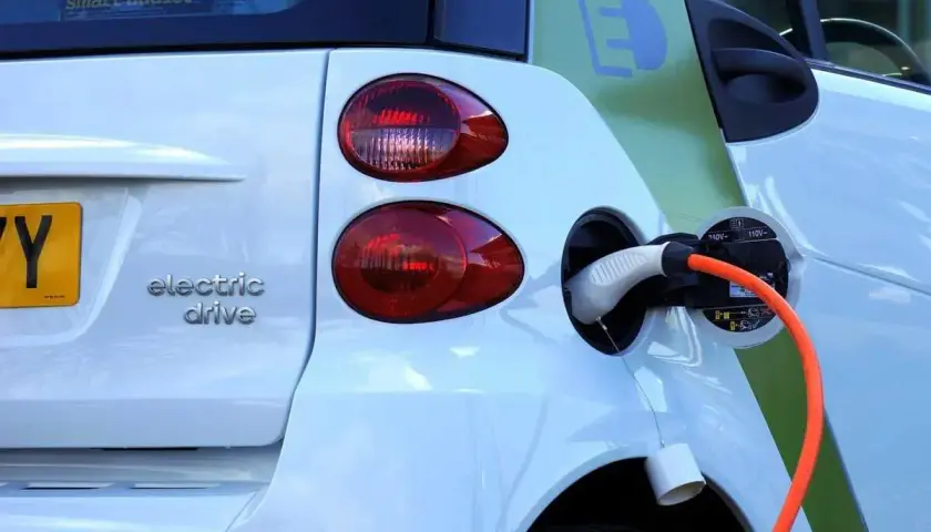 Une voiture électrique blanche est branchée. La question est : peut-on laisser charger une batterie de voiture toute la nuit ?