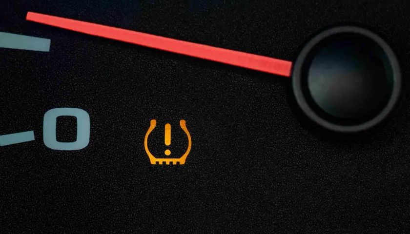 Voyant orange en forme de pneu avec un point d'exclamation, indiquant un problème de pression pneu.