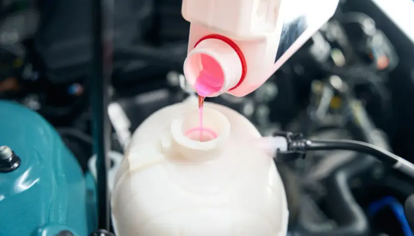 Remplissage du réservoir d'expansion avec du liquide de refroidissement OAT rose pour assurer le bon fonctionnement du moteur.