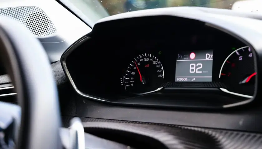 Tableau de bord d'une voiture affichant 82 km/h. Pour savoir si une voiture est gagée, vérifiez son historique.