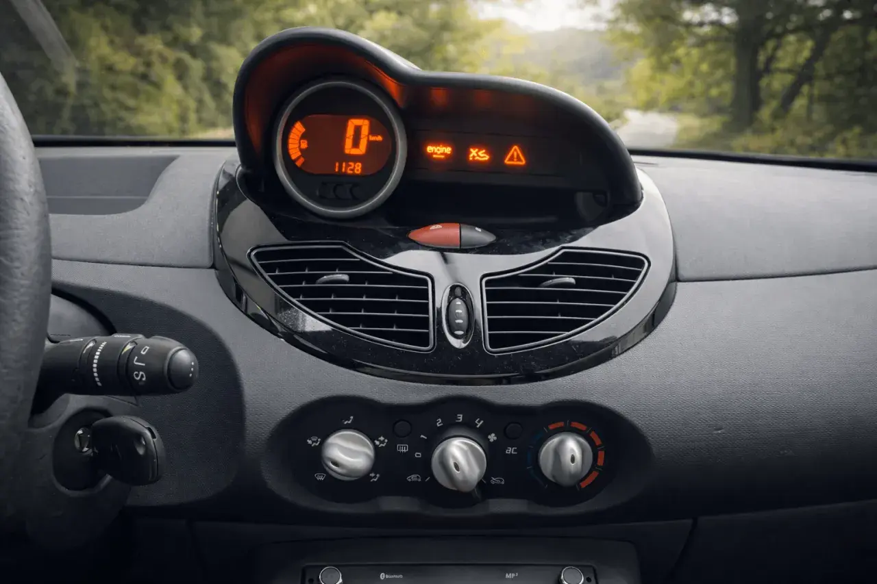 Tableau de bord d'une Twingo 2, prêt pour la vidange. Le compteur affiche 0 km/h, avec des voyants moteur et d'alerte allumés.