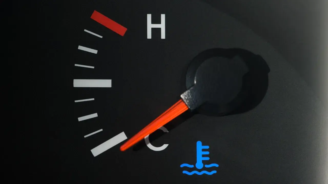 Indicateur de température de voiture avec aiguille sur la zone bleue et symbole de thermomètre.