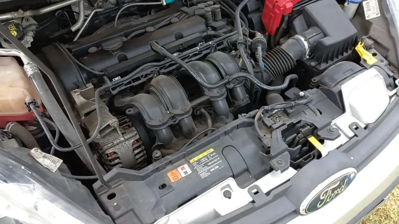 Moteur de Ford Fiesta essence. Le démarreur est caché sous le collecteur d'admission, près de l'alternateur.