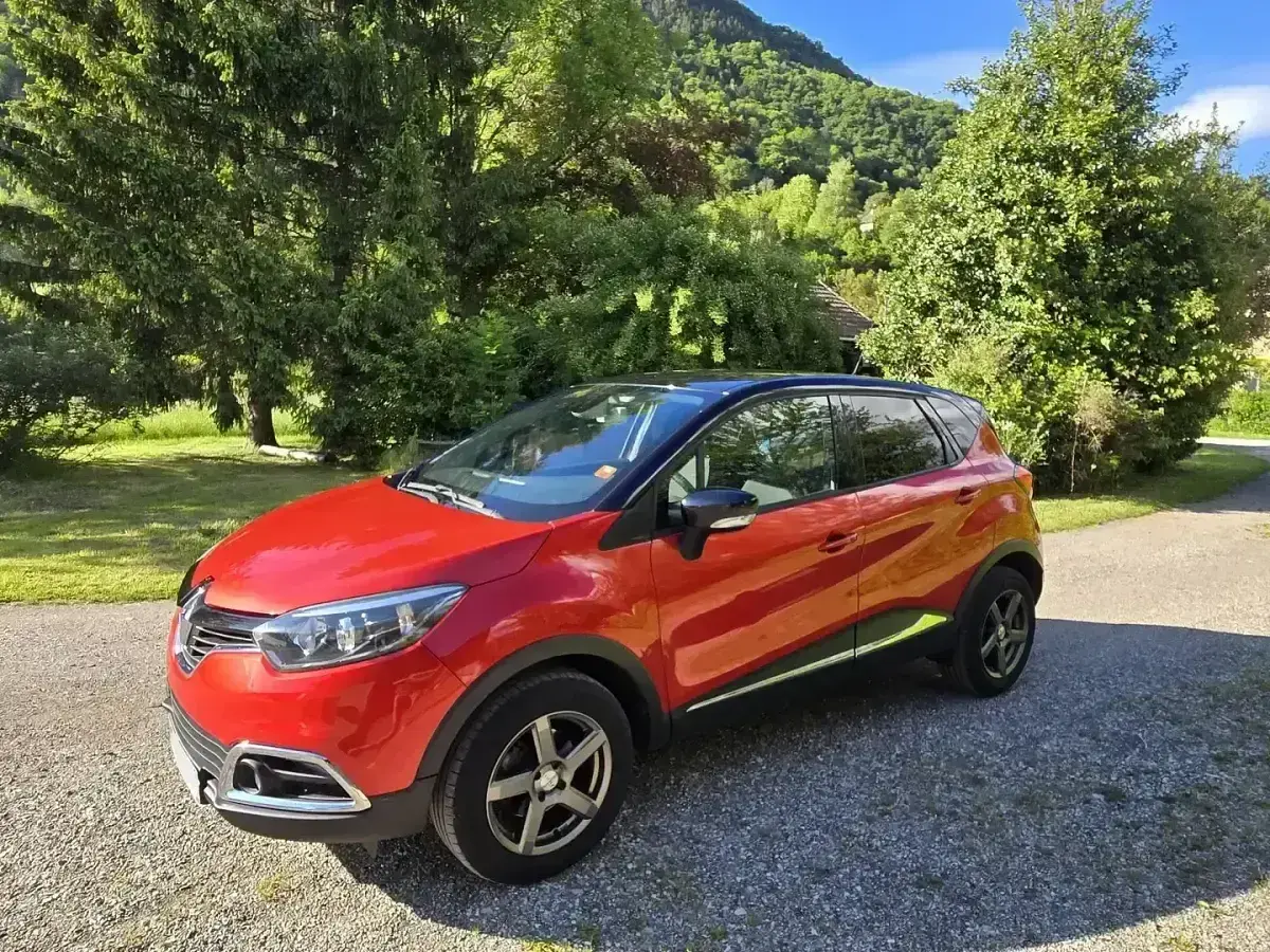 Renault Captur rouge garé dans un paysage verdoyant. Idéal pour connaître le prix révision Renault Captur 60000 km.