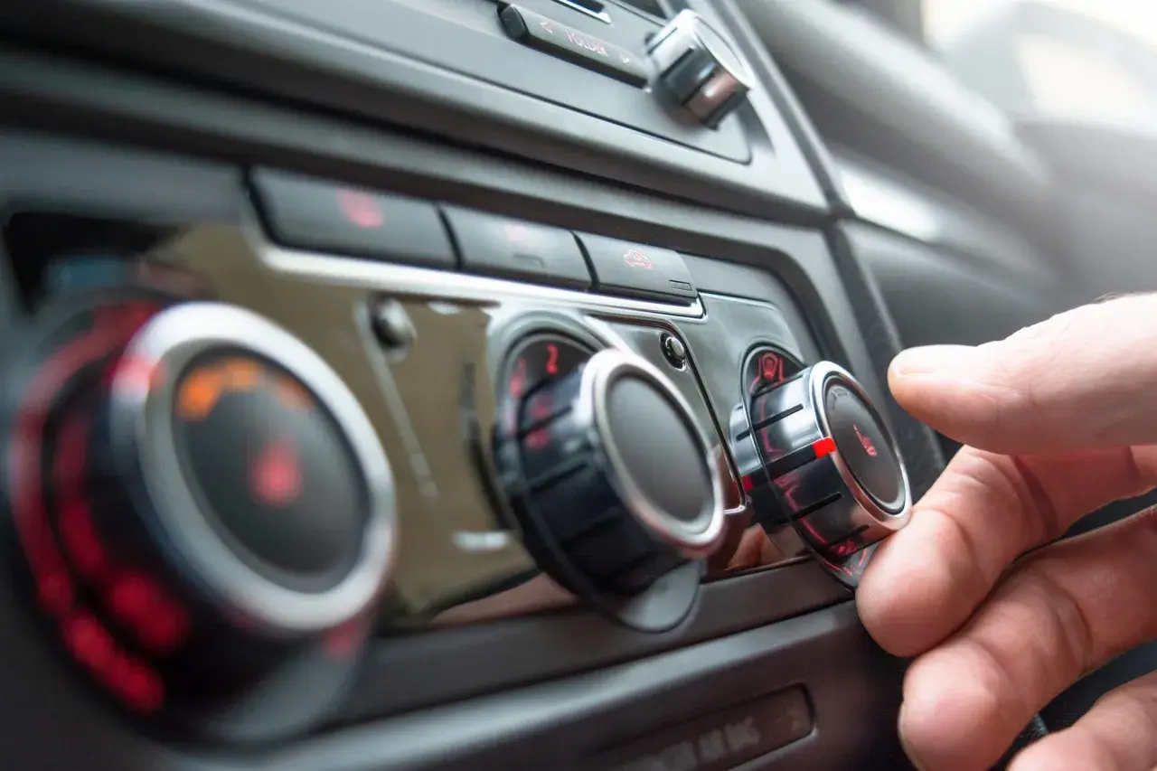 Main gauche sur le bouton de température, le chauffage de la voiture est réglé au maximum. Le liquide de refroidissement est peut-être bas.
