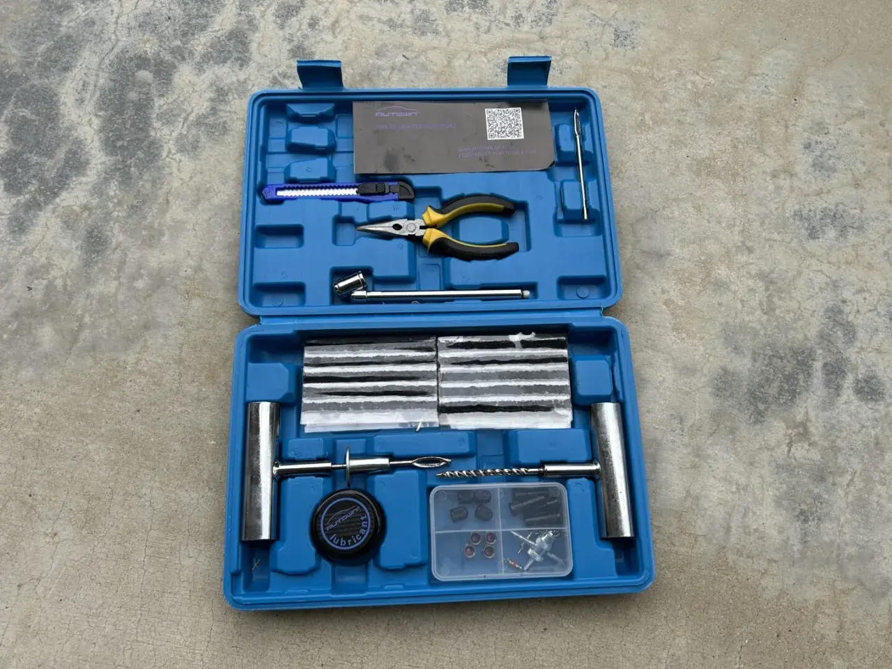 Kit de réparation pour pneu de voiture : mèches, pince, cutter, et outils pour une intervention rapide.