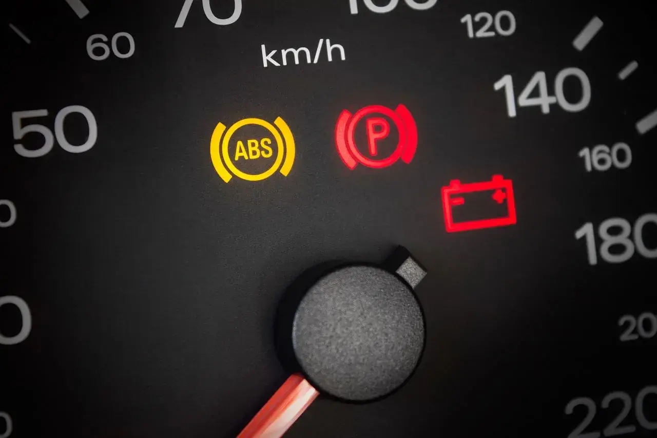 Voyant ABS allumé, un symptôme possible d'un capteur ABS défectueux. Le tableau de bord affiche aussi les voyants de frein de parking et de batterie.