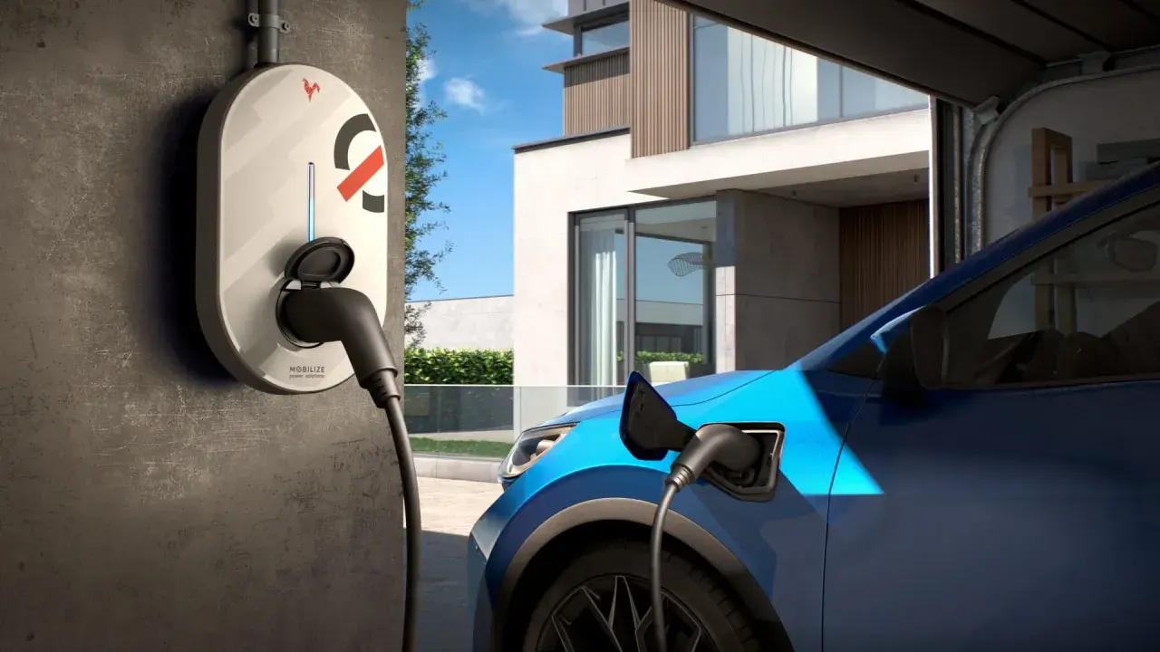 Borne de recharge électrique connectée à une voiture bleue devant une maison moderne. Idéal pour savoir où recharger voiture électrique.