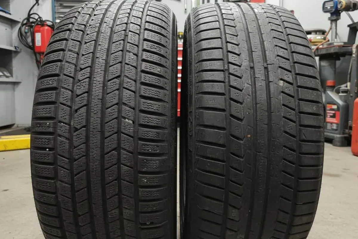 Deux pneus côte à côte : l'un avec un profil profond et lamellisé pour l'hiver, l'autre plus lisse. Apprenez à reconnaître pneu hiver et 4 saisons.