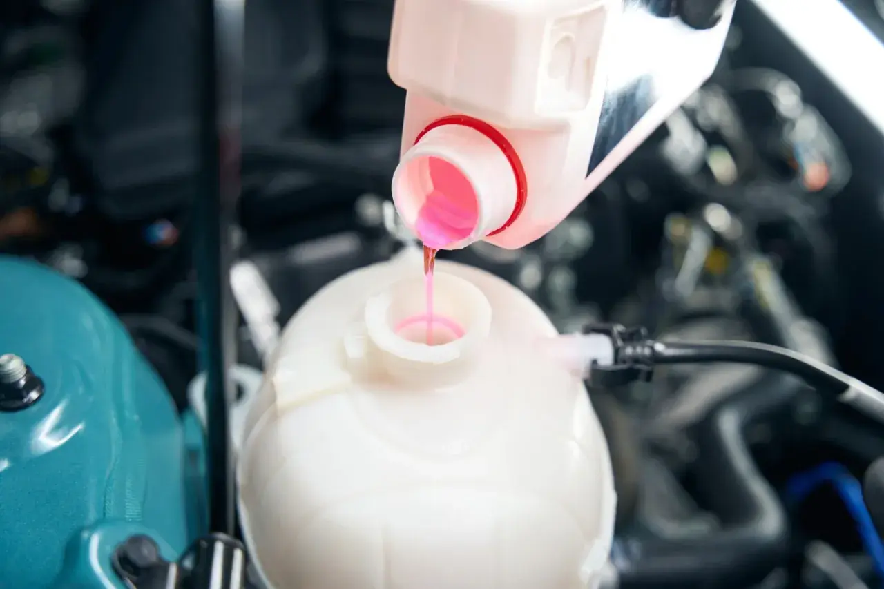 Remplissage du réservoir d'expansion avec du liquide de refroidissement OAT rose pour assurer le bon fonctionnement du moteur.