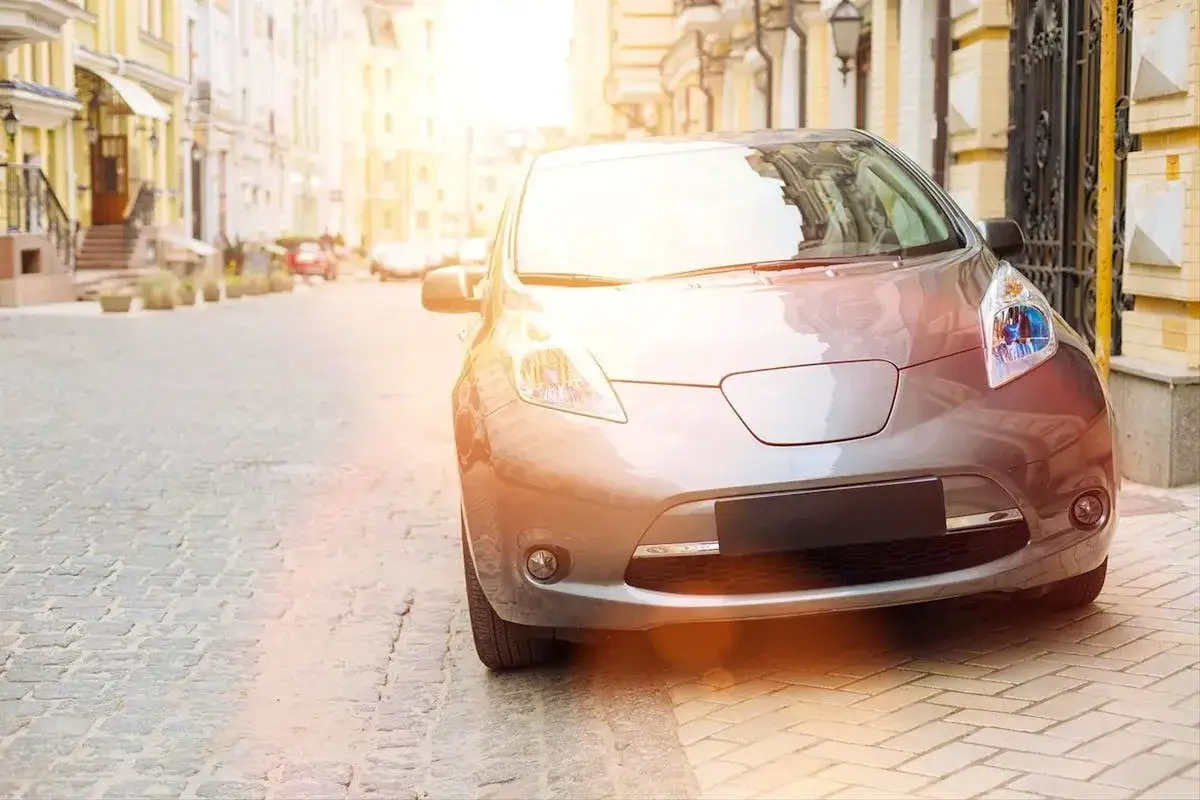 Voiture gar&eacute;e depuis des mois, elle attend patiemment sur la rue pav&eacute;e, baign&eacute;e par la lumi&egrave;re dor&eacute;e du soleil.