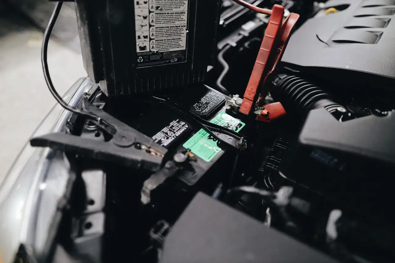 Pinces de démarrage sur batterie de voiture. Si votre voiture ne démarre pas, cela peut être des symptômes de relais démarreur HS.