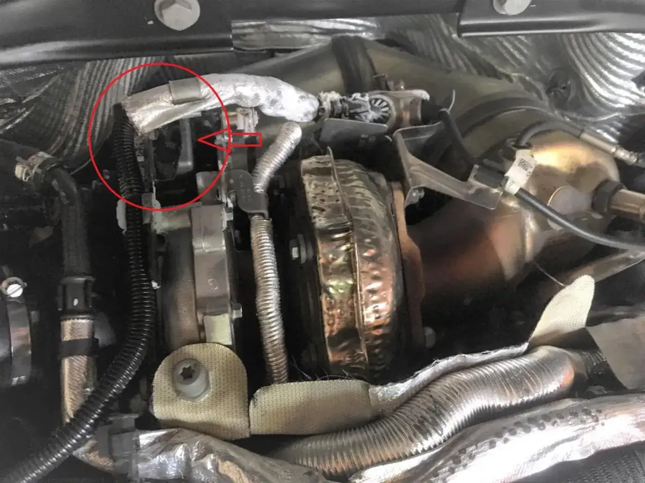 Zone rouge sur un moteur, indiquant une possible fuite injecteur AdBlue. Composants du turbo et tuyaux isolés visibles.