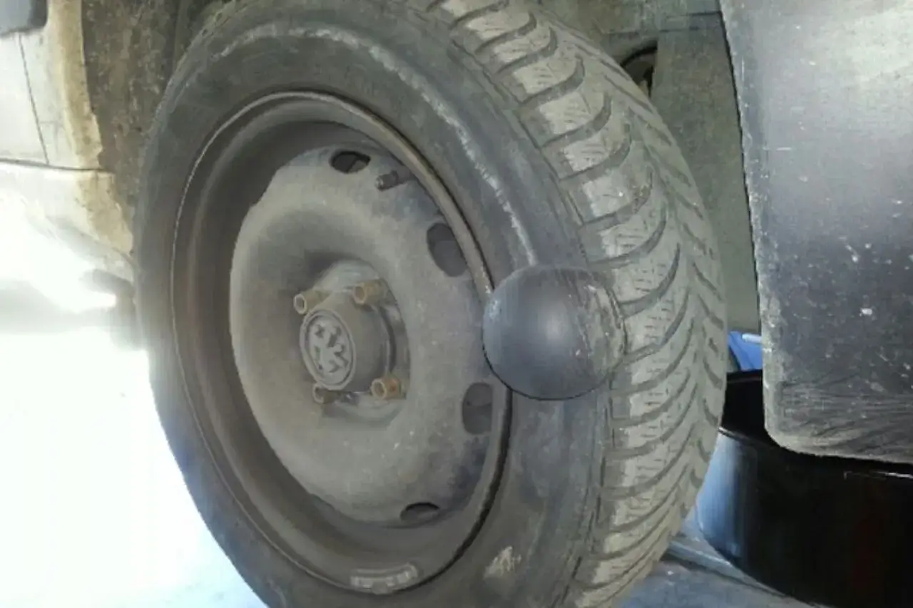 Gros plan d'une roue de voiture avec une hernie sur le pneu, signe d'un problème de sécurité.