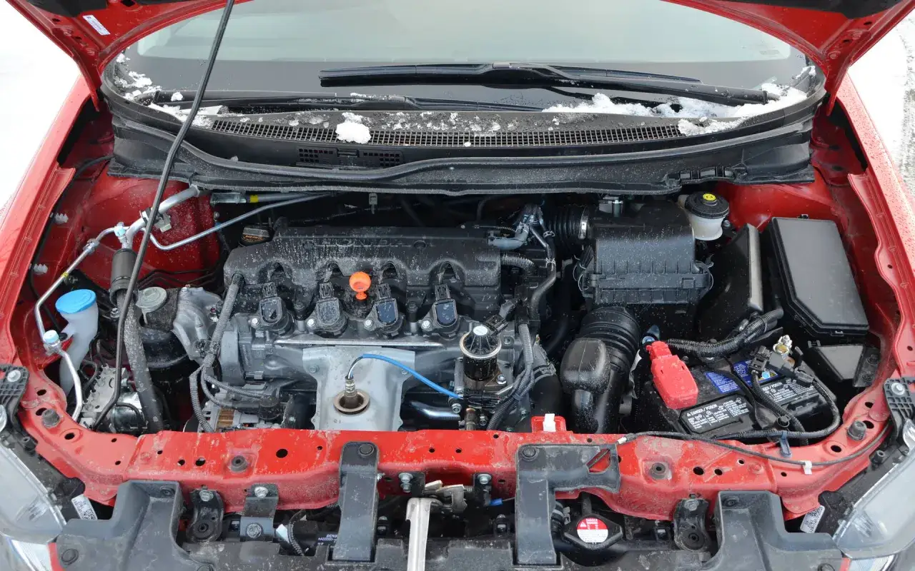 Moteur de voiture rouge sous la neige. Si le moteur est noyé, combien de temps attendre avant de le démarrer ?