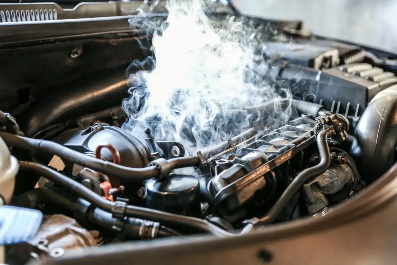 Fumée s'échappant d'un moteur de voiture, peut-être un injecteur qui claque.
