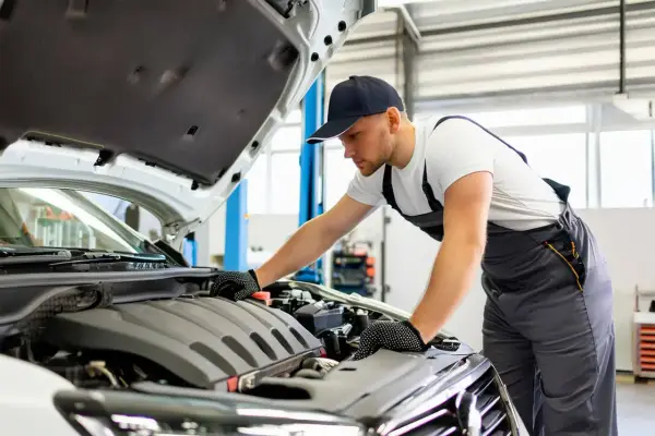 Mécanicien vérifiant le moteur d'une BMW Série 1. Il est temps de vérifier où mettre le liquide de refroidissement.